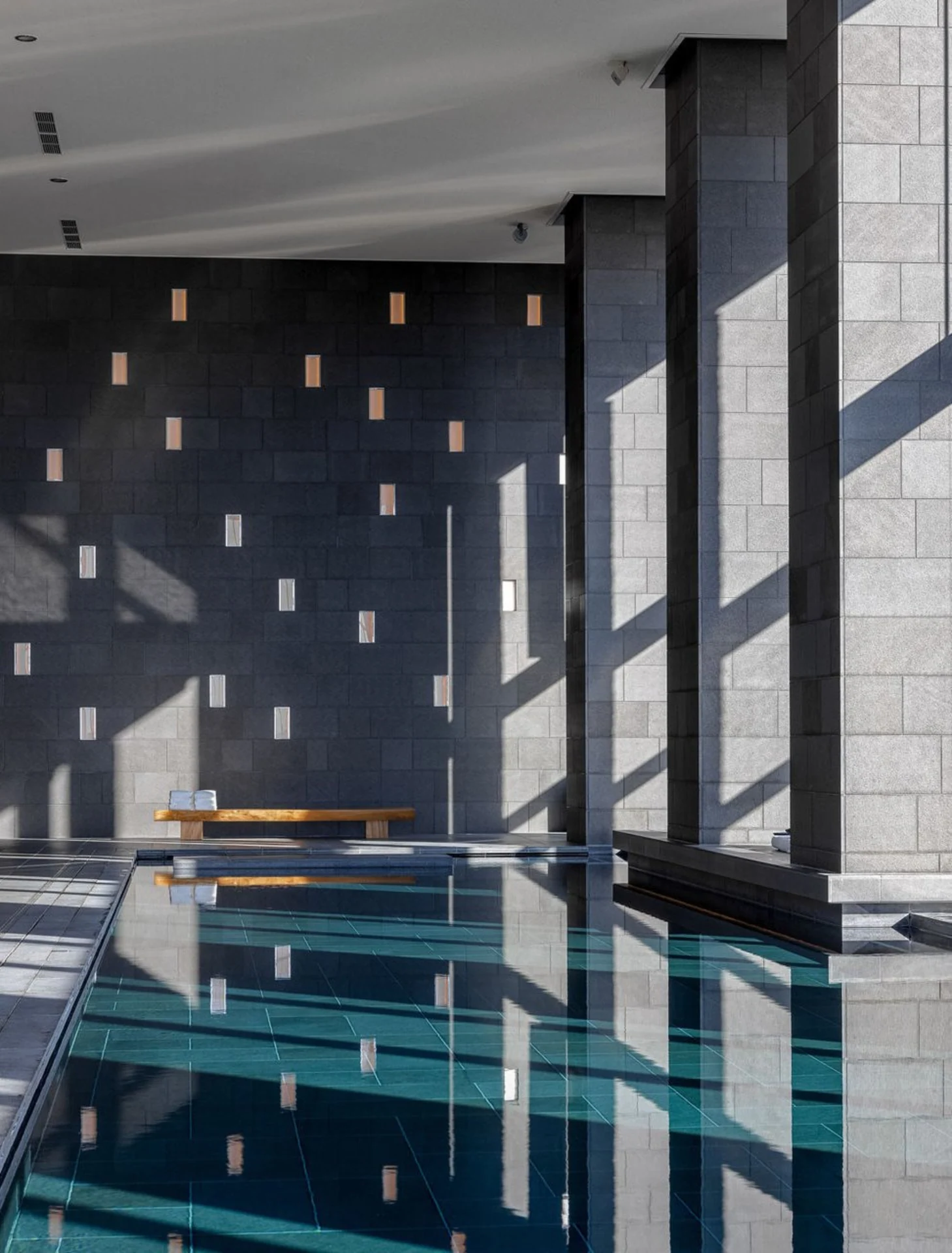 Piscina interna do Aman Tokyo com grandes janelas para a cidade