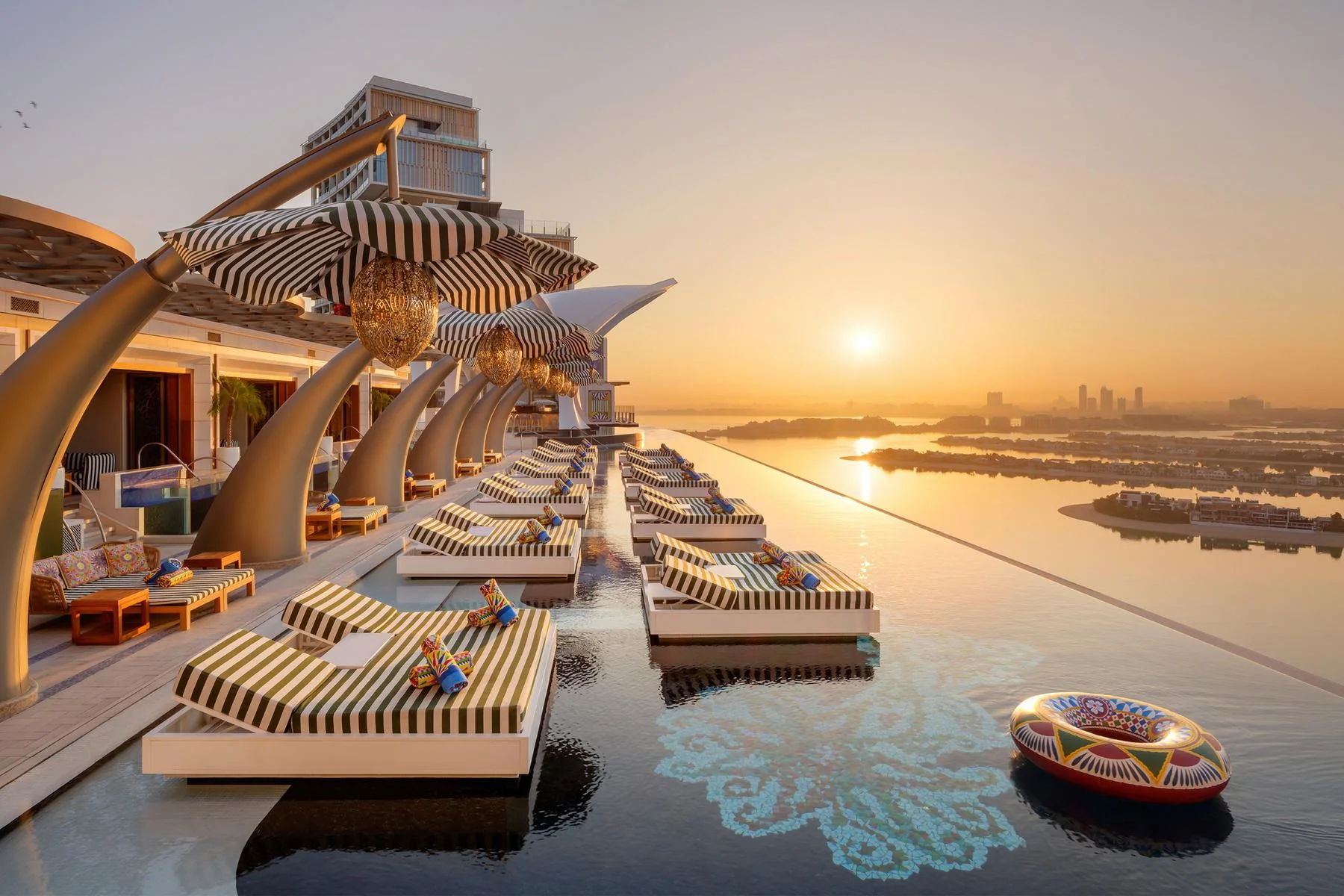 Piscina e espreguiçadeiras do Cloud 22 no Atlantis The Royal ao pôr do sol