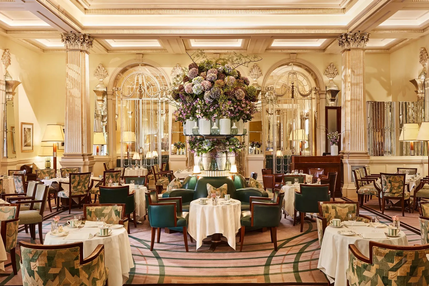 Foyer e Reading Room do Claridge’s com mesas e flores