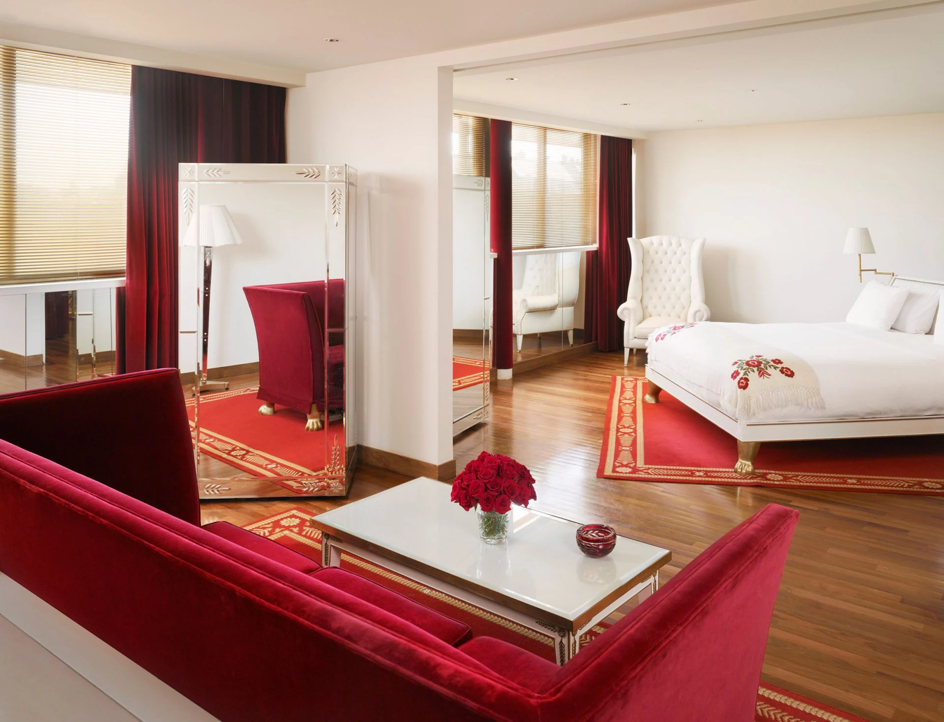 Suíte do Faena Buenos Aires com mobiliário branco e detalhes vermelhos