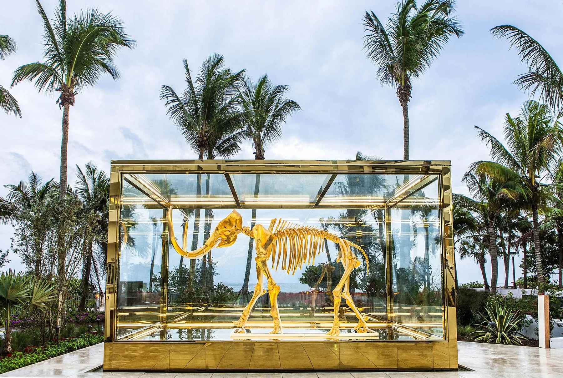 Mamute dourado em vitrine junto às palmeiras do Faena Miami Beach