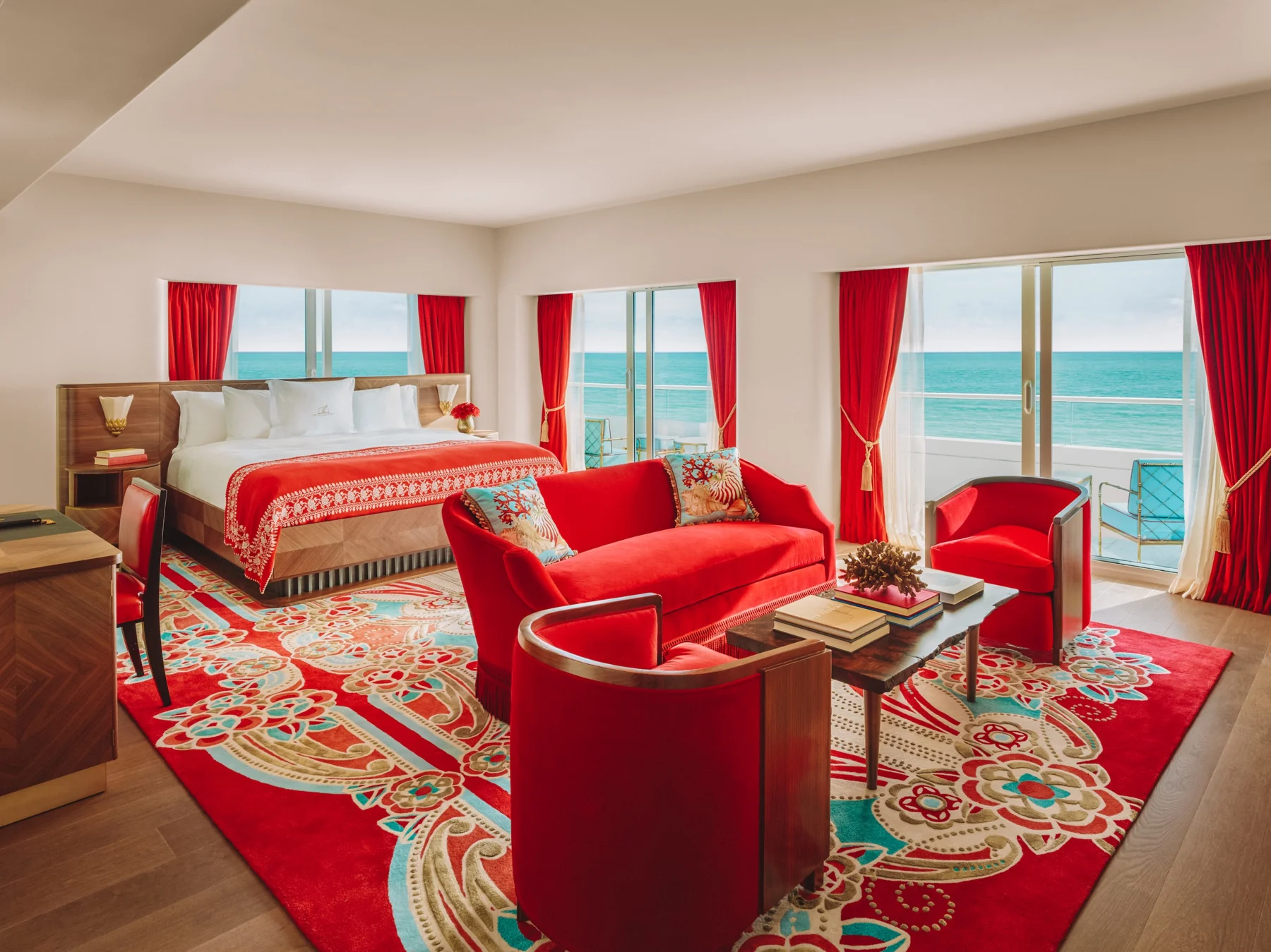 Suíte do Faena Miami Beach com mobiliário vermelho e vista do oceano