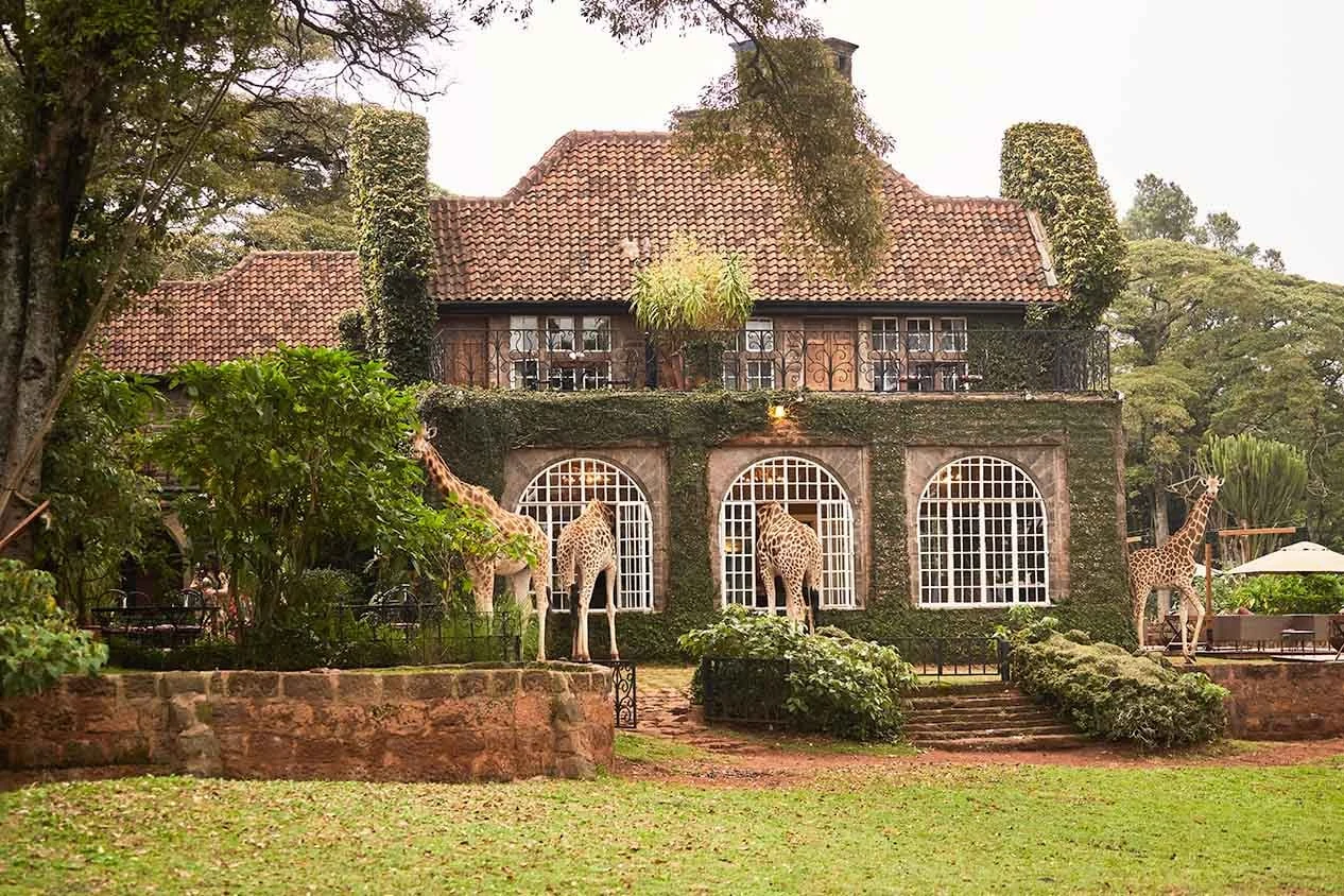 Fachada histórica do Giraffe Manor cercada por jardins