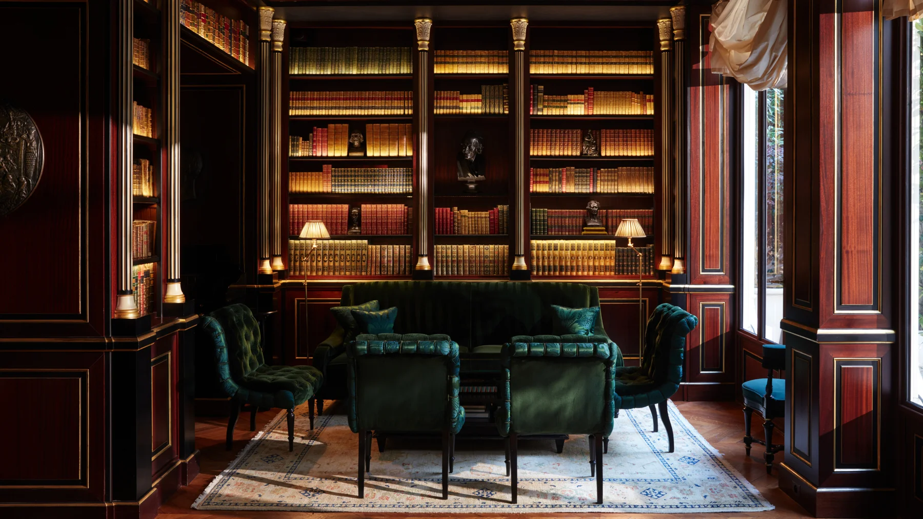 Biblioteca da La Réserve Paris com estantes e decoração clássica
