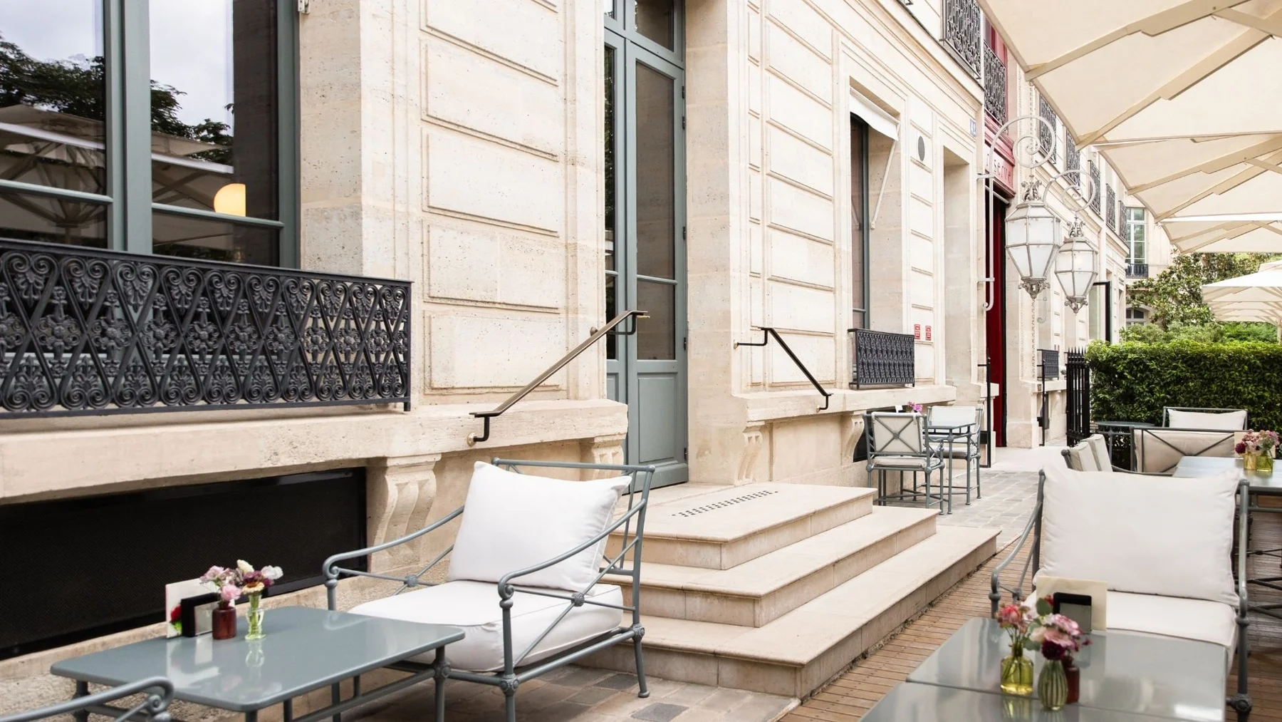 Terraço da La Réserve Paris com mesas diante da fachada clássica