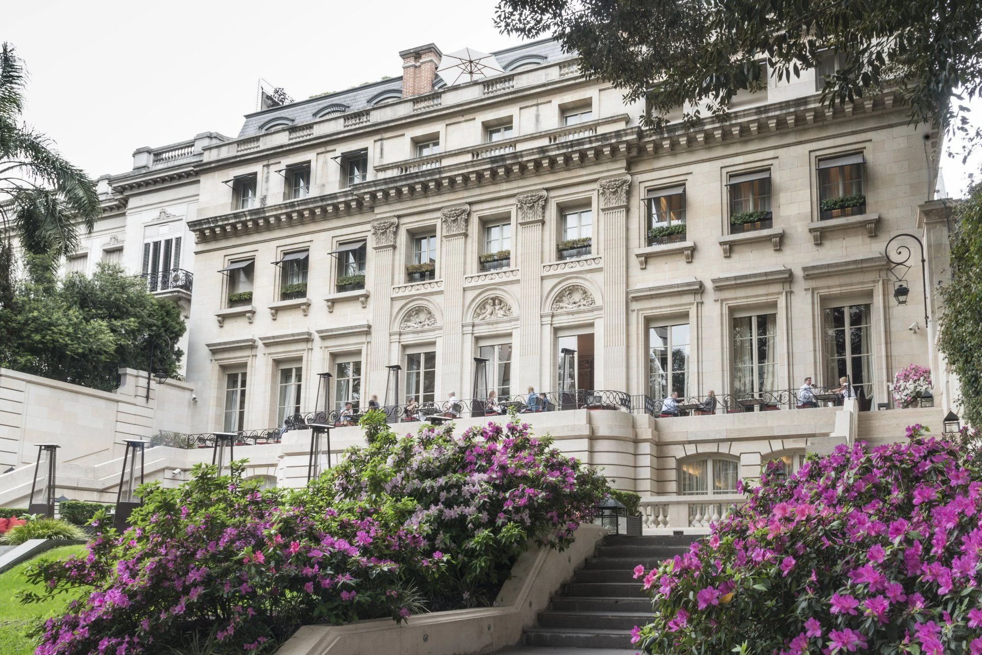 Jardins floridos e fachada histórica do Palacio Duhau em Buenos Aires
