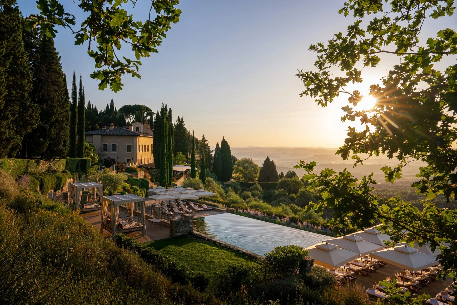 Piscina e borgo do Rosewood Castiglion del Bosco em luz dourada