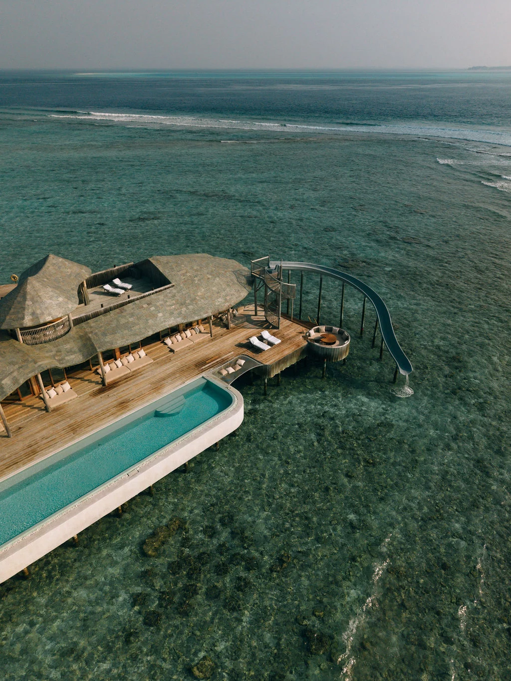 Villa sobre a água do Soneva Fushi com piscina e escorregador