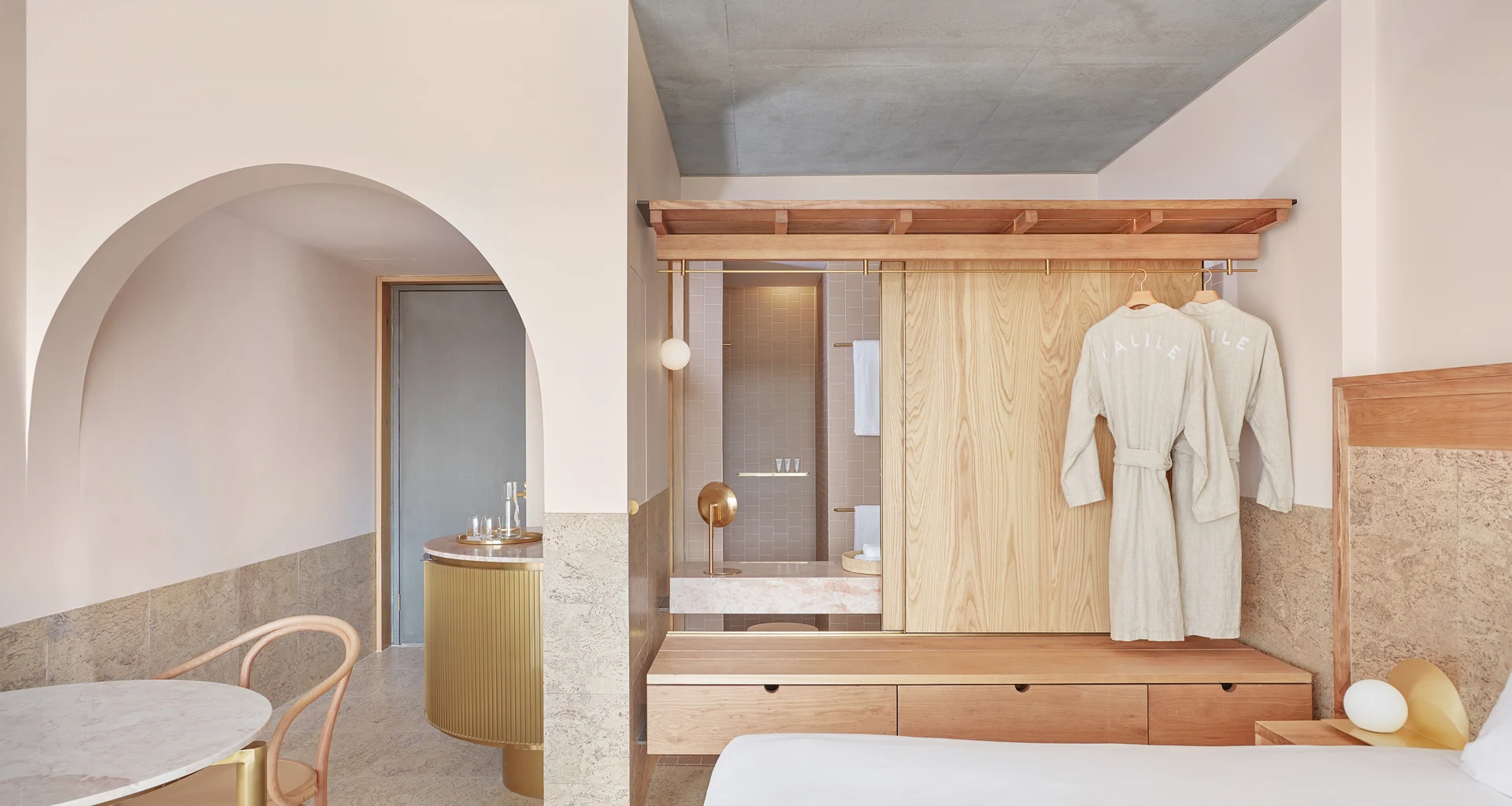Quarto do The Calile com arcos e revestimentos em tons claros