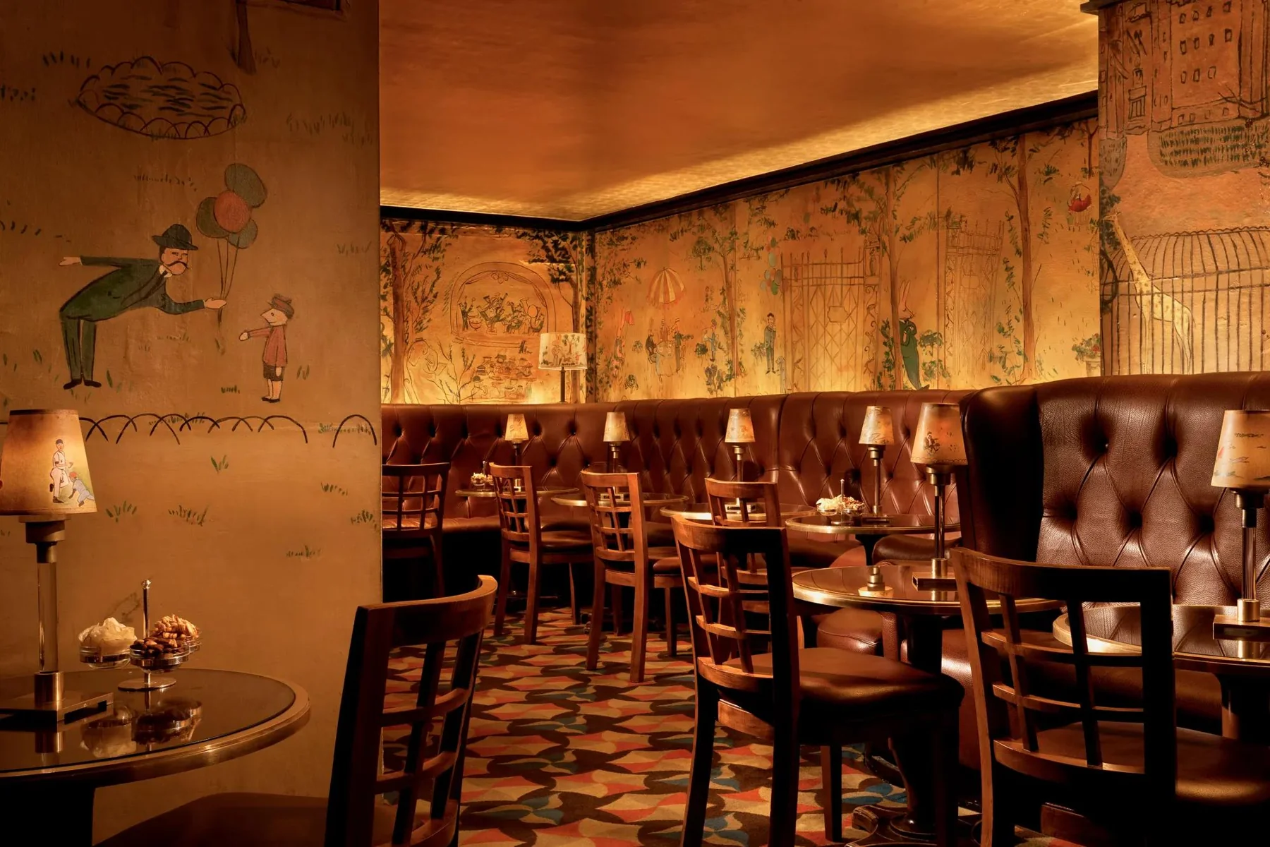 Bemelmans Bar do The Carlyle com murais e iluminação âmbar